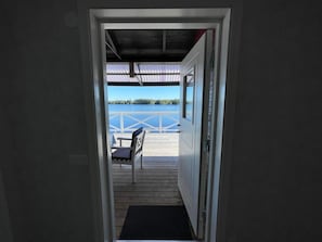A doorway leading to a deck with a view of a body of water and a dock. - 4 Star Holiday Home in Bruzaholm (Bruzaholm)