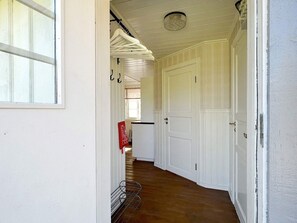 A hallway with white doors, a metal rack, and a red fire extinguisher. - 4 Person Holiday Home in Hacksvik-by Traum (Håcksvik)