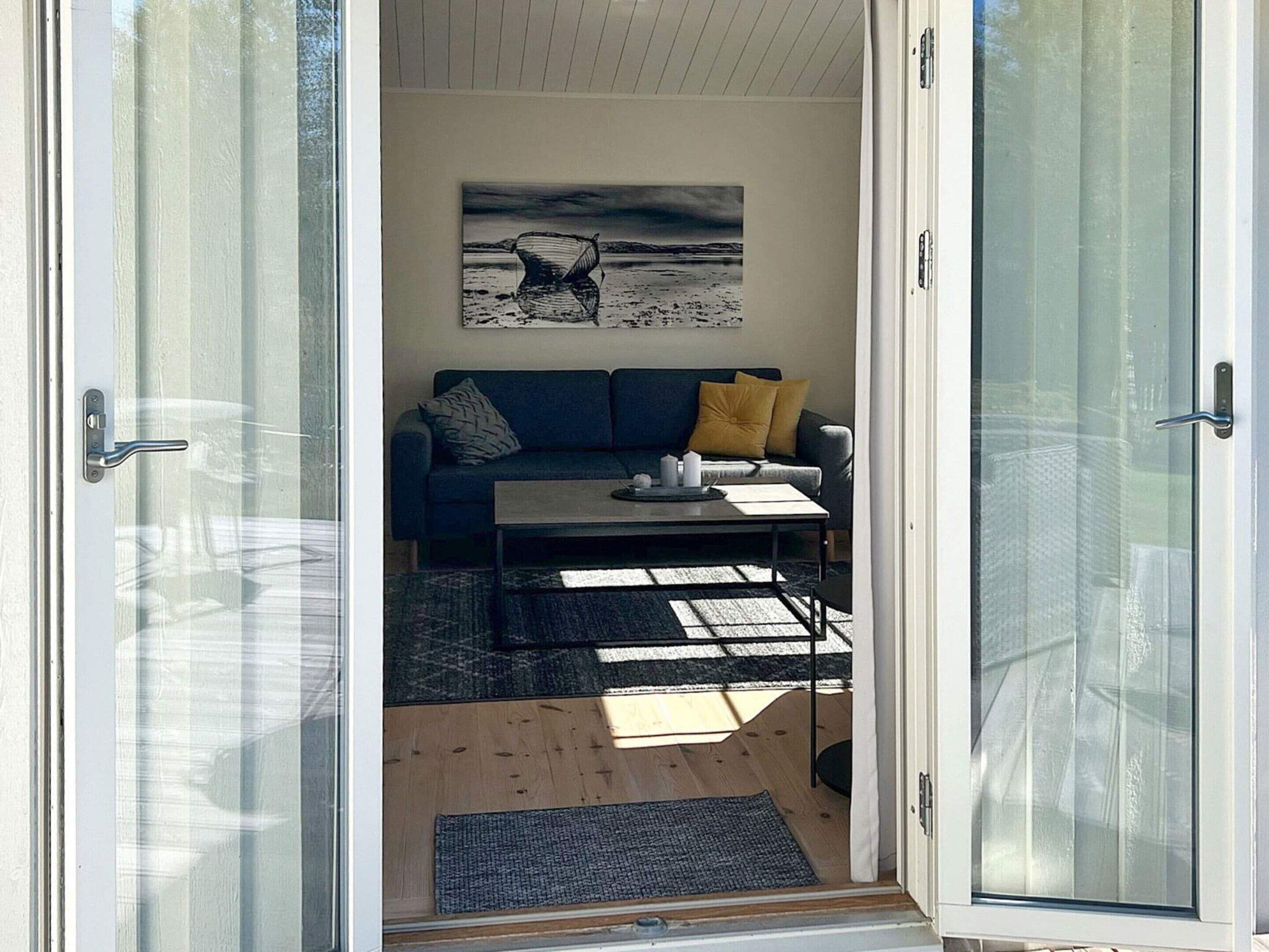 A room with a sofa, a coffee table, and a painting on the wall.