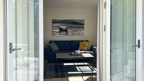 A room with a sofa, a coffee table, and a painting on the wall. - 4 Person Holiday Home in Hacksvik (Håcksvik)