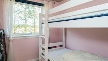 Dormitorio con literas, ventana, suelo de madera y paredes rosas.