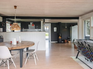 Une cuisine moderne avec une table en bois, des chaises et un fourneau.