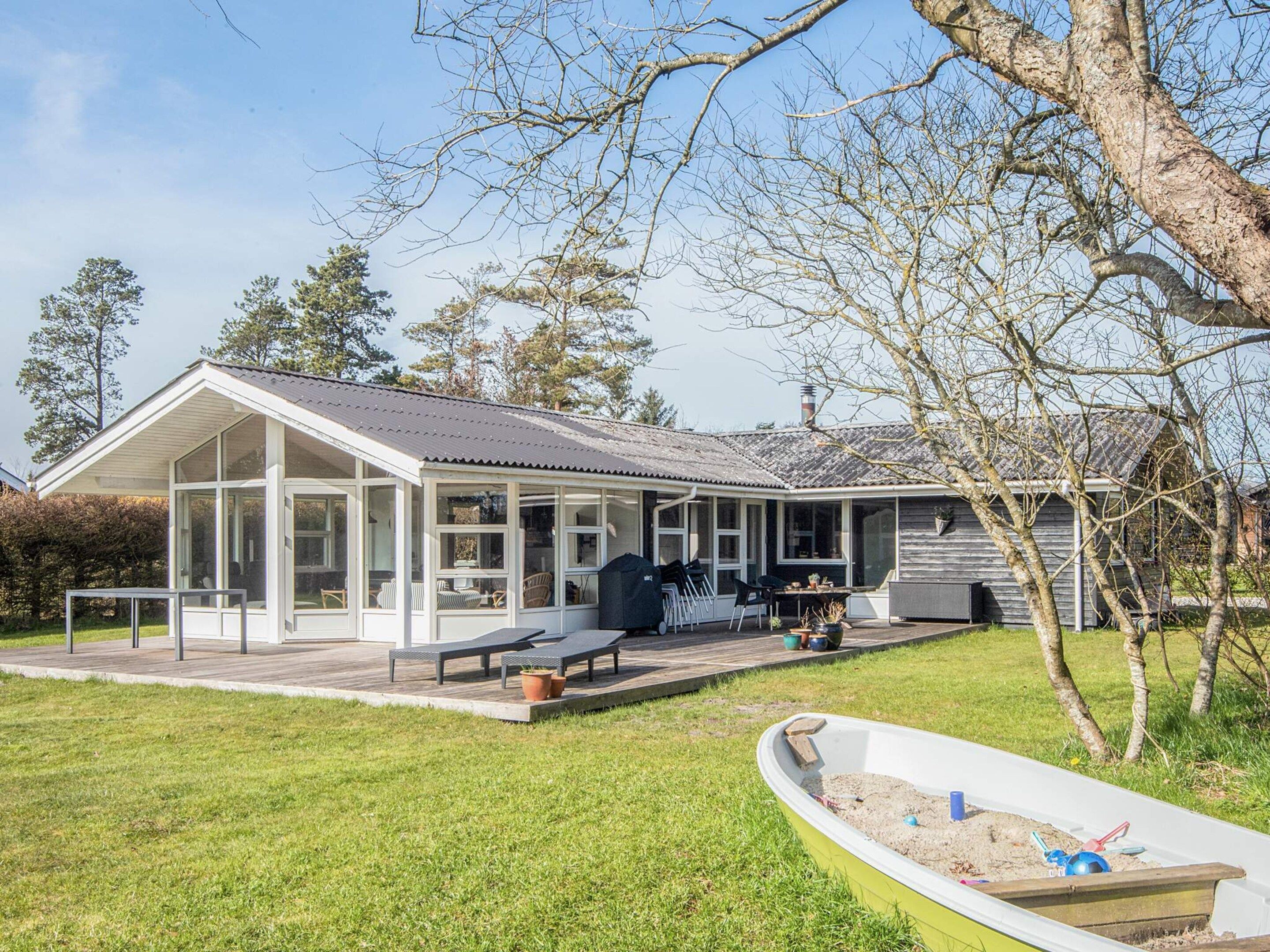 A house with a covered patio, outdoor seating, and a swimming pool.