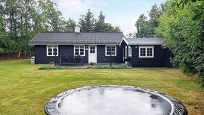 A two-story house with a front porch and a trampoline in the yard. - 4 Person Holiday Home in Hals (Hals)