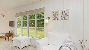 A room with a white sofa, a small table, and a large window. - 4 Person Holiday Home in Hals (Hals)