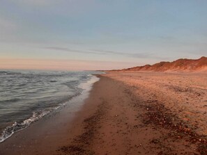 A beach with a sandy shore and a rocky cliff in the background.