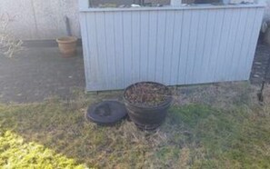 A small outdoor area with a metal trash bin and a wooden fence. - 4 Person Holiday Home in Hjorring (Hjørring)