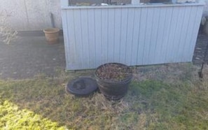 A small outdoor area with a metal trash bin and a wooden fence. - 4 Person Holiday Home in Hjorring (Hjørring)