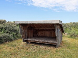 A wooden structure with a sloped roof and a bench outside. - 4 Star Holiday Home in Hjorring (Hjørring)
