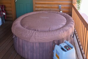Ein Whirlpool mit Bedienfeld auf einer Holzterrasse.