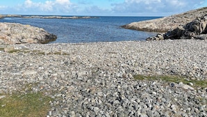 A rocky beach with pebbles and a calm sea. - 11 Person Holiday Home in Tarva (Orland)