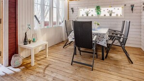 A wooden deck with a table and chairs, a bench, and a window with curtains. - 11 Person Holiday Home in Tarva (Orland)