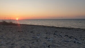 A beach with a sunset over the ocean. - 4 Person Holiday Home in Nakskov (Nakskov)