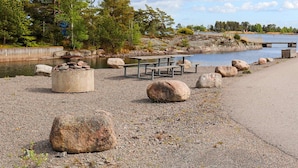 Ein Picknickplatz am Seeufer mit Bänken und einer Feuerstelle.