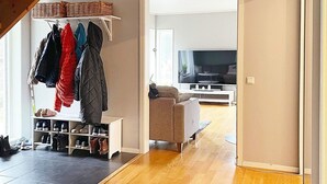 A living room with a TV, a sofa, and a shoe rack. - 6 Person Holiday Home in Bjorklinge-by Traum (Björklinge)