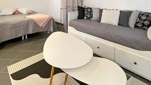 Una camera da letto moderna con un letto, una poltrona e un tavolino.