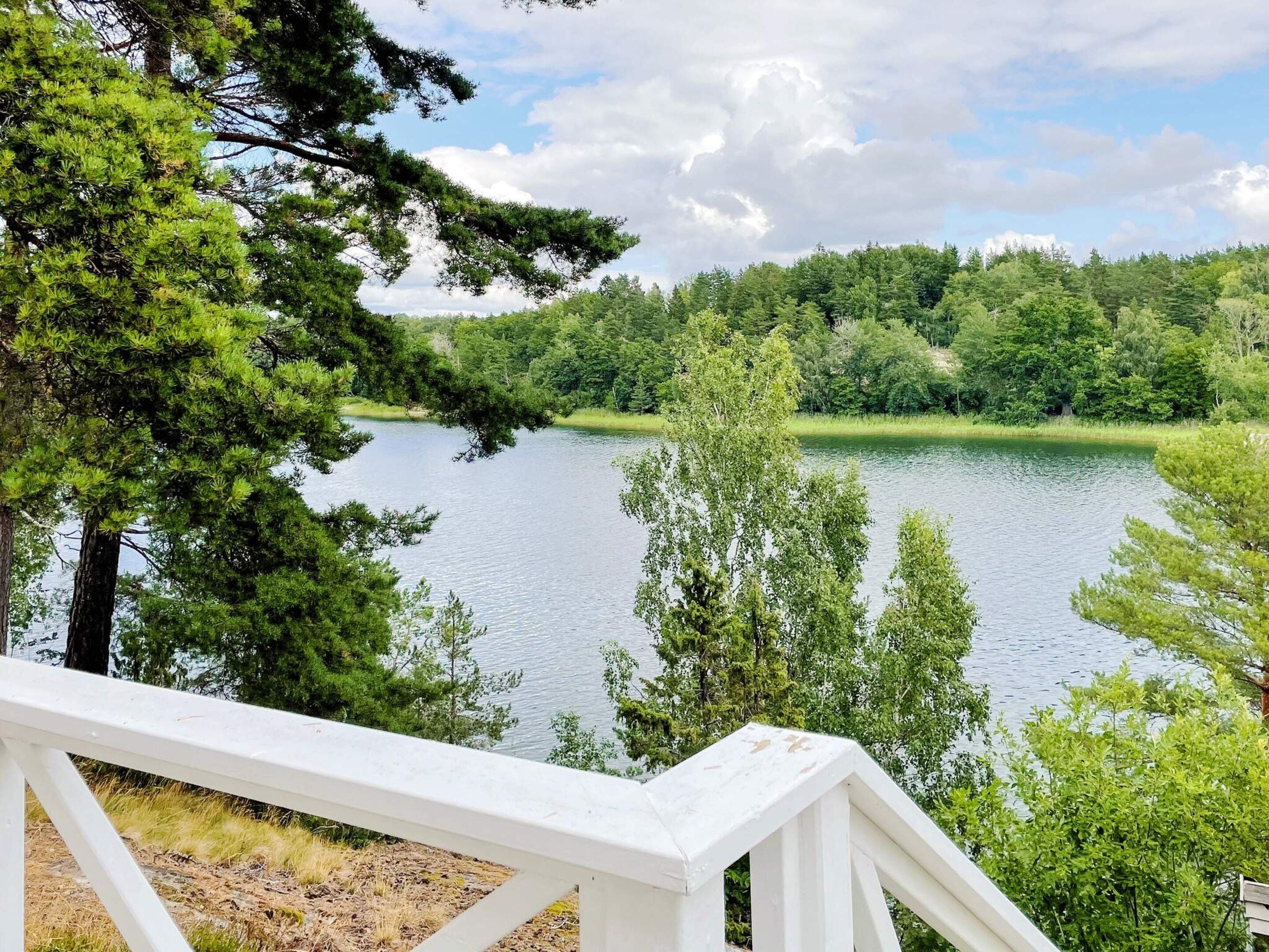A lakeside view with a white deck overlooking the water.