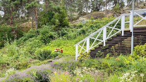 A wooden staircase leading up a hill, surrounded by lush greenery and various flowering plants. - 4 Star Holiday Home in Ingaro (Ingaro)