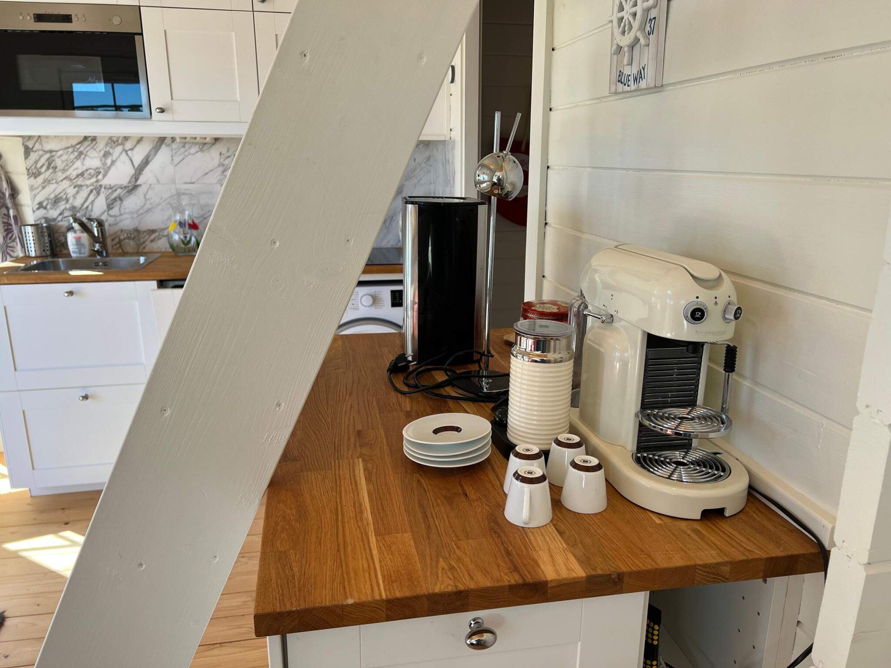 Una cocina con encimera de madera, cafetera y microondas.