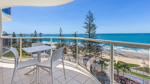 A balcony with a table and chairs overlooking a beach and ocean. - ZANZIBAR APT 802- OCEAN VIEW APARTMENT (Mooloolaba)