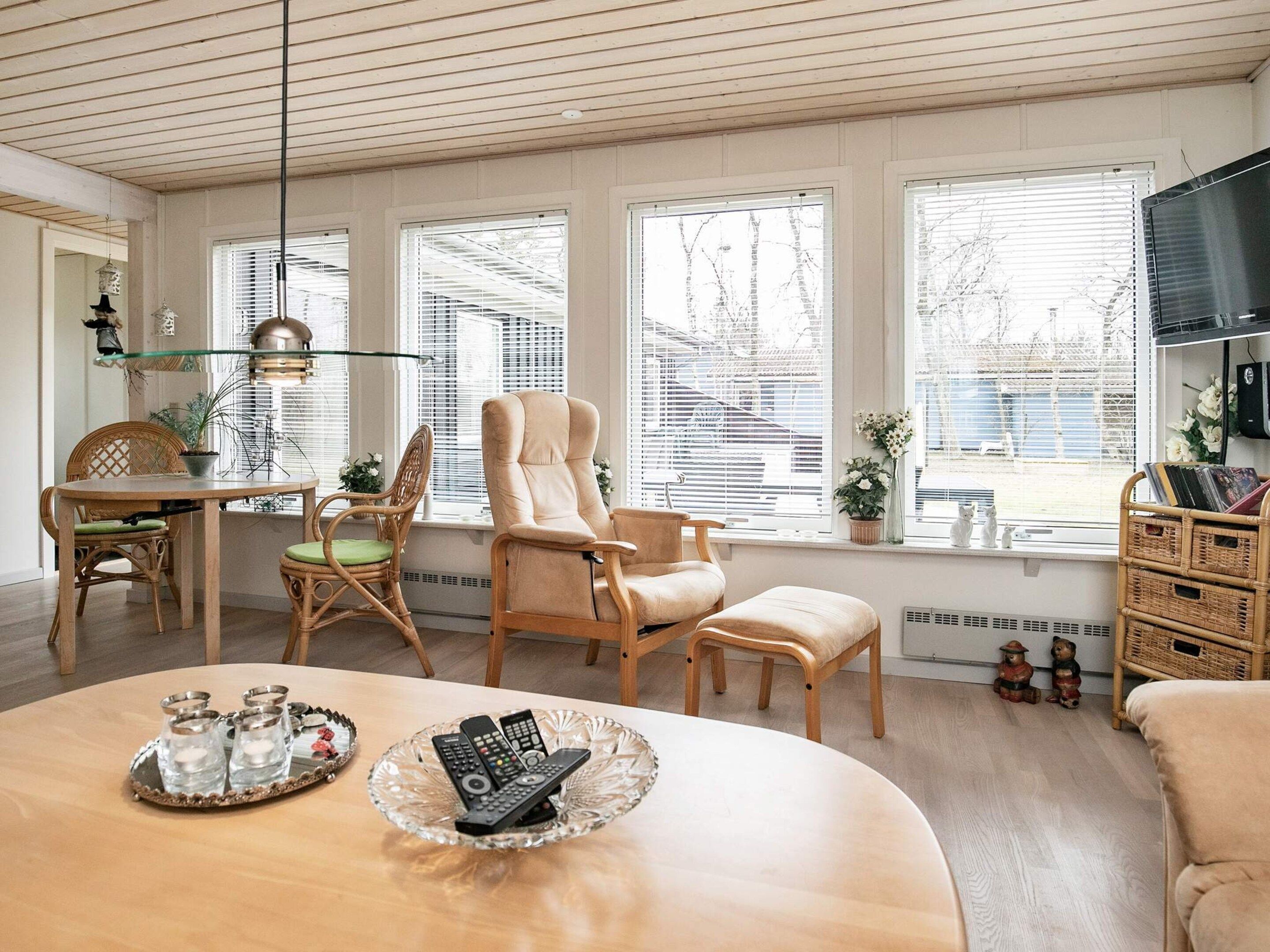 A living room with a round table, two chairs, a sofa, and a television.