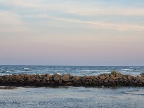 Et kystlandskab med en stenvæg og havet.
