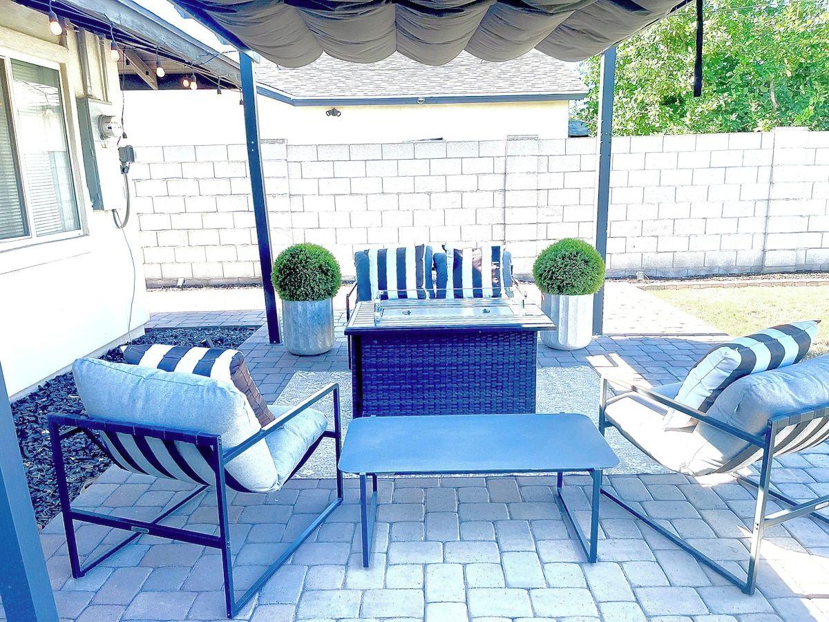 An outdoor patio with a seating area, a table, and two planters.