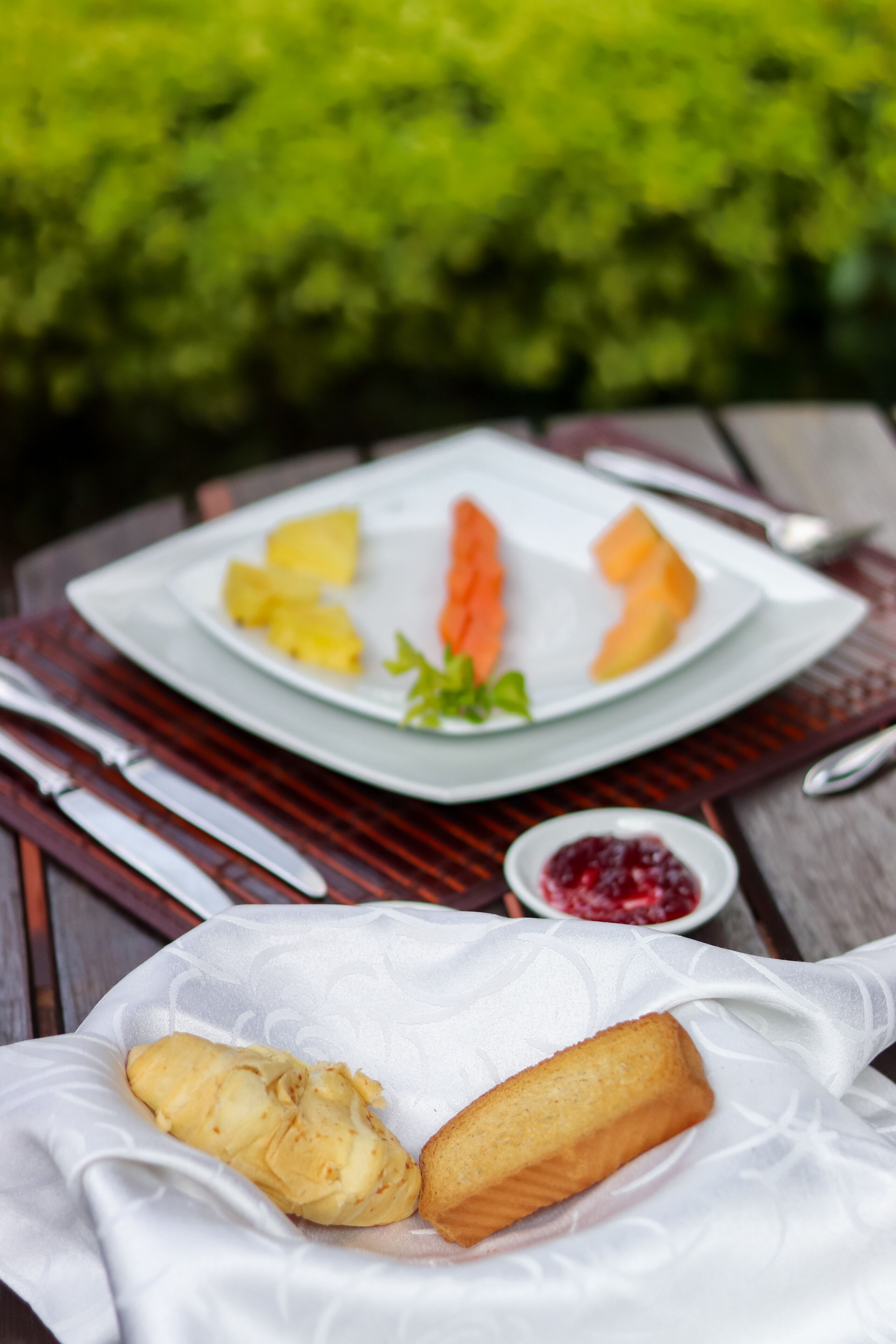 Una comida con una fuente de fruta y una cesta de comida frita sobre una mesa.