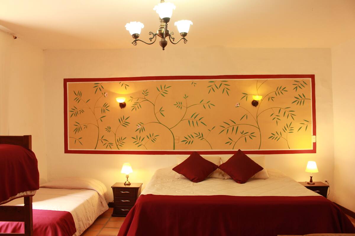 Een hotelkamer met twee bedden, een kroonluchter, wanddecoratie en bedlampjes.