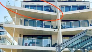 A multi-story hotel with balconies, a staircase, and a glass facade.