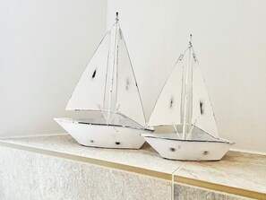 To hvide sejlbåde med sorte detaljer på en flisetag.