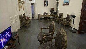 Ein geräumiges Wohnzimmer mit Flachbildfernseher, bequemen Sitzmöglichkeiten und Deckenventilator.