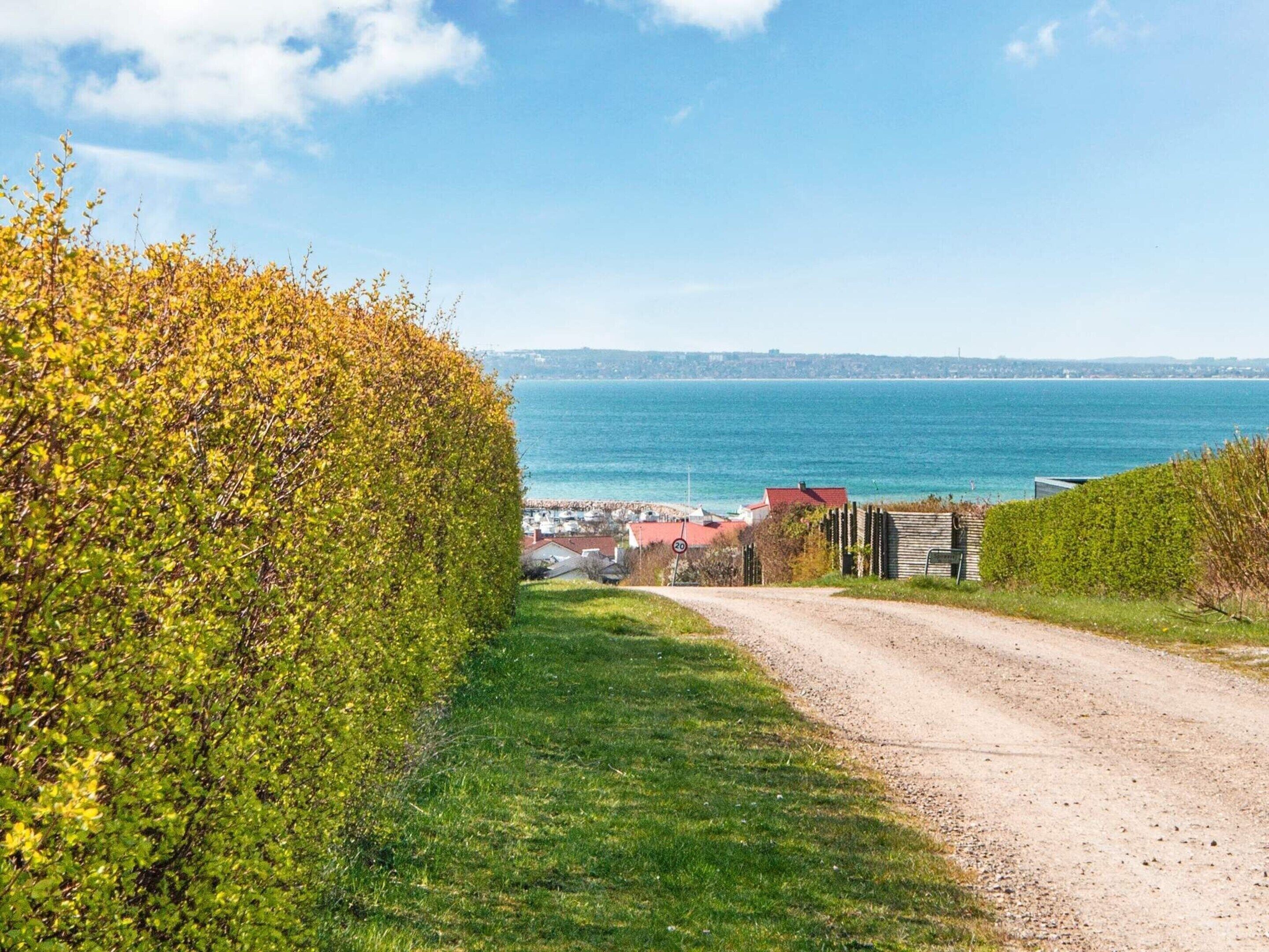 A coastal road with a clear view of the sea and a distant town.