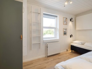 A bedroom with a bed, a window, a radiator, and a door. - 5 Star Holiday Home in Thisted (Thisted)