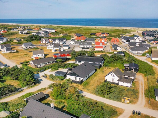 A coastal residential area with houses, a beach, and a clear view of the sea. - 5 Star Holiday Home in Thisted (Thisted)