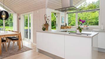 Una cocina moderna con una isla grande, mesa de comedor de madera y sillas.