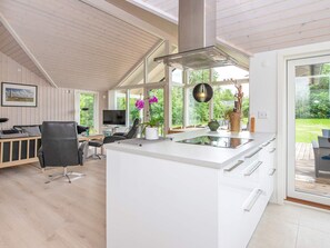 A modern kitchen with a central island, large windows, and a view of the outdoors. - 6 Person Holiday Home in Oksbol (Oksbol)
