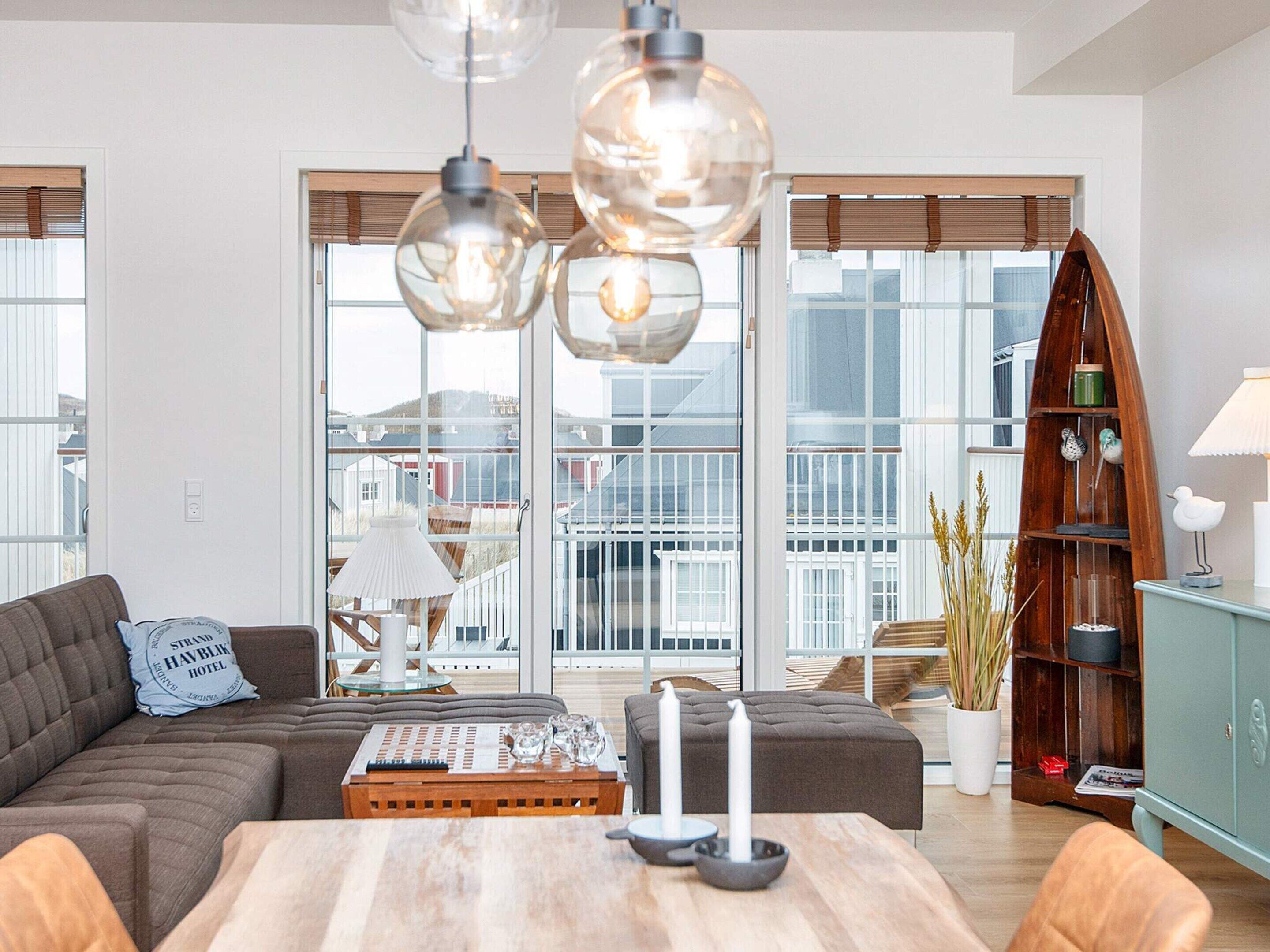Un salon moderne avec un canapé d’angle, une table basse en bois et une bibliothèque.