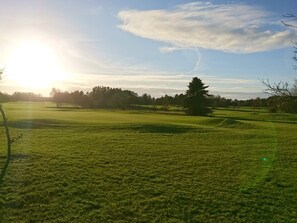 A golf course with a clear sky and sunlight. - 6 Person Holiday Home in Nibe (Nibe)