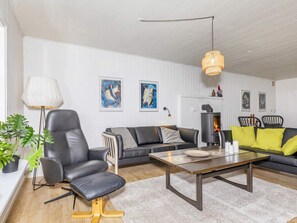 A modern living room with a sofa, armchair, and coffee table. - 6 Person Holiday Home in Nibe (Nibe)
