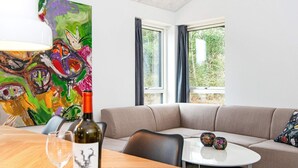 A modern living room with a beige sofa, a round coffee table, and a painting on the wall.