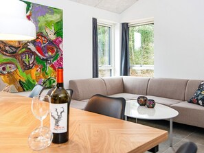 A modern living room with a beige sofa, a round coffee table, and a painting on the wall.