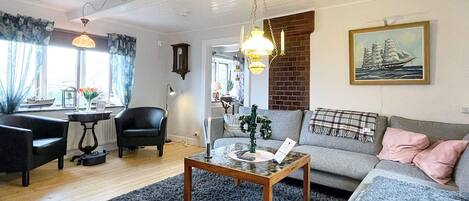 A living room with a sofa, armchair, coffee table, and a fireplace.