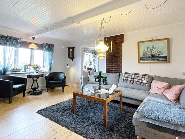A living room with a sofa, armchair, coffee table, and a fireplace.