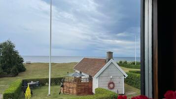 A coastal property with a small house, a flag, and a view of the sea.