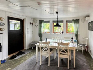 Ein Essbereich mit einem weißen Tisch, Stühlen und einer Pendelleuchte.