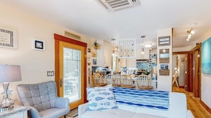 Una sala moderna con un sofá, una silla y un comedor con mesa y sillas.