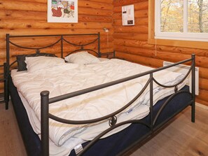 A bed with a metal frame in a wooden cabin room. - 4 Star Holiday Home in Hadsund (Hadsund)
