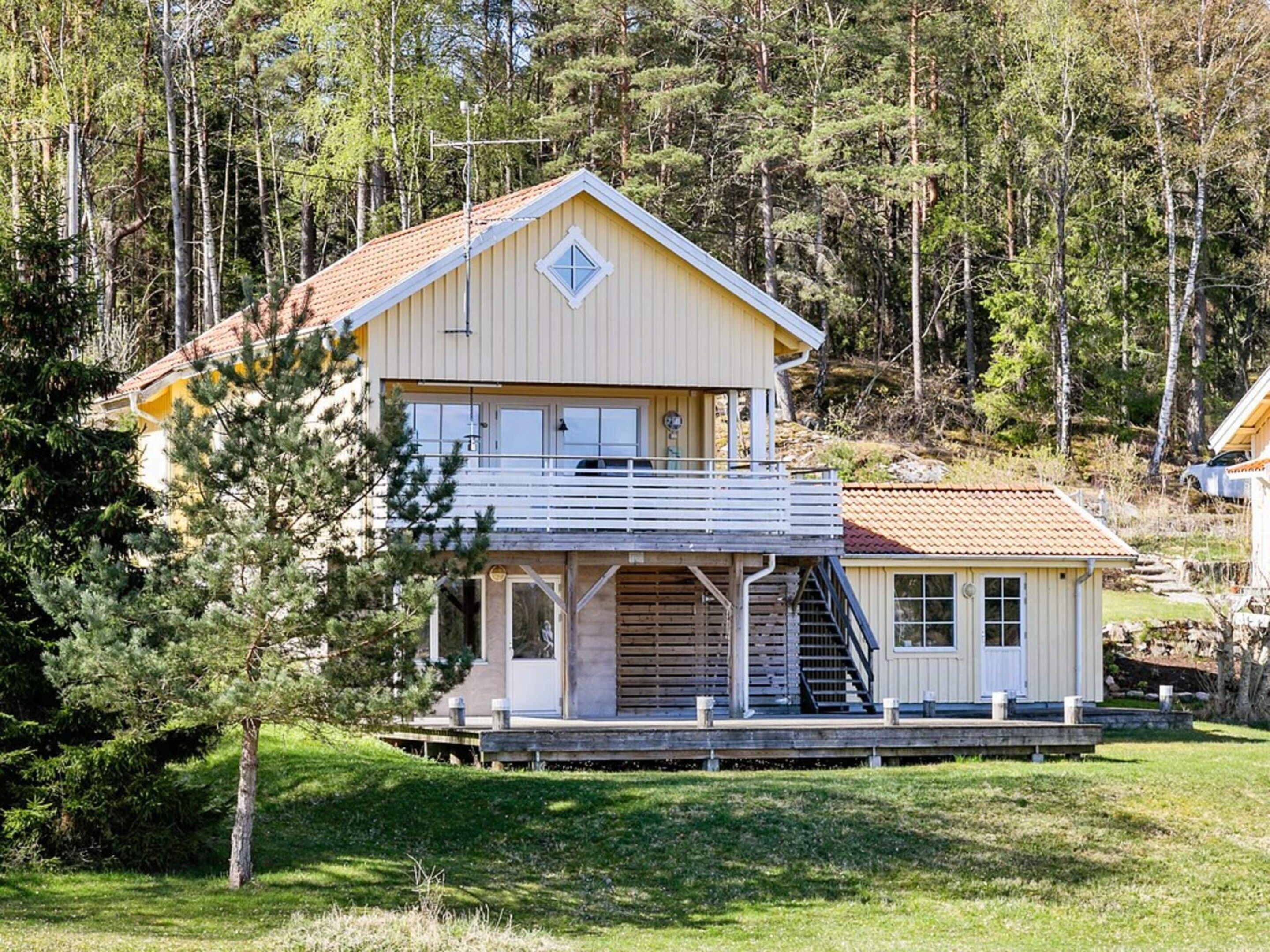 Un bâtiment à deux étages doté d’un balcon, entouré d’arbres.