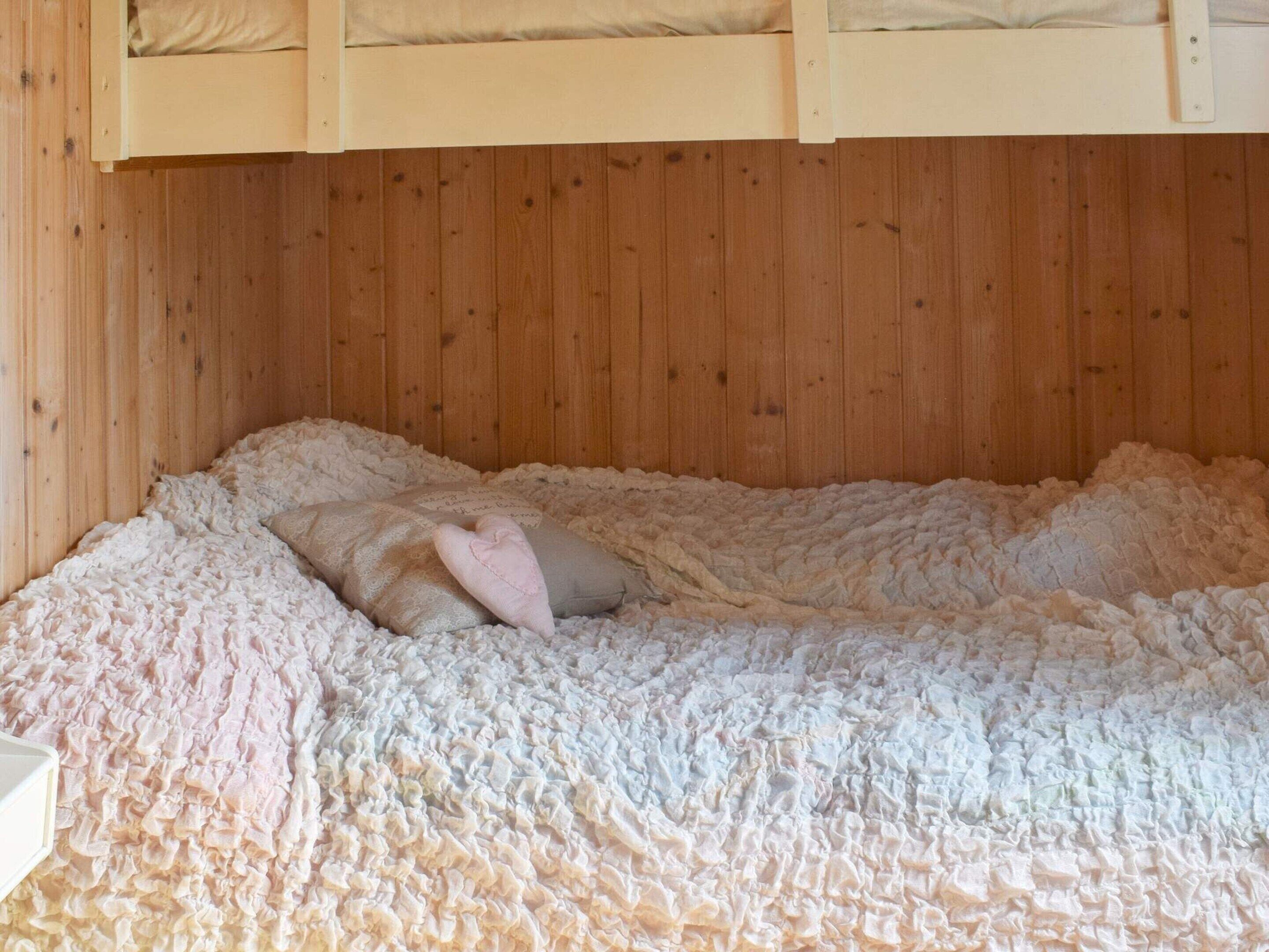 A bunk bed with a fluffy, textured blanket and pillows.